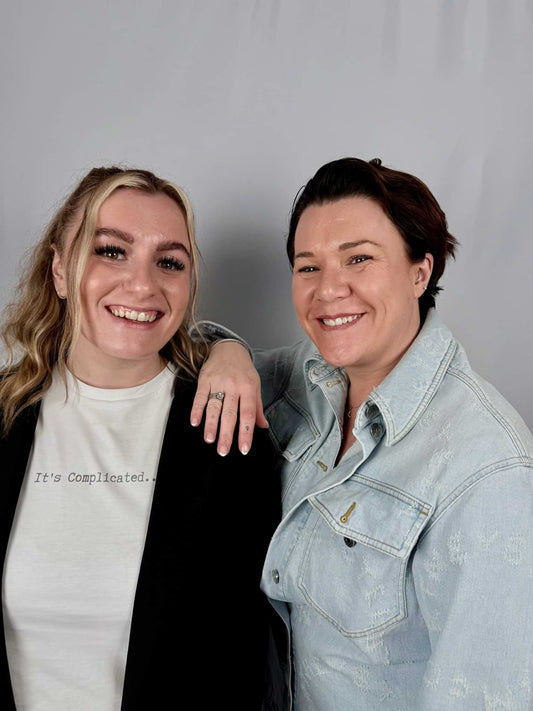 picture of two woman smiling one with black cardigan and one with denim shirt