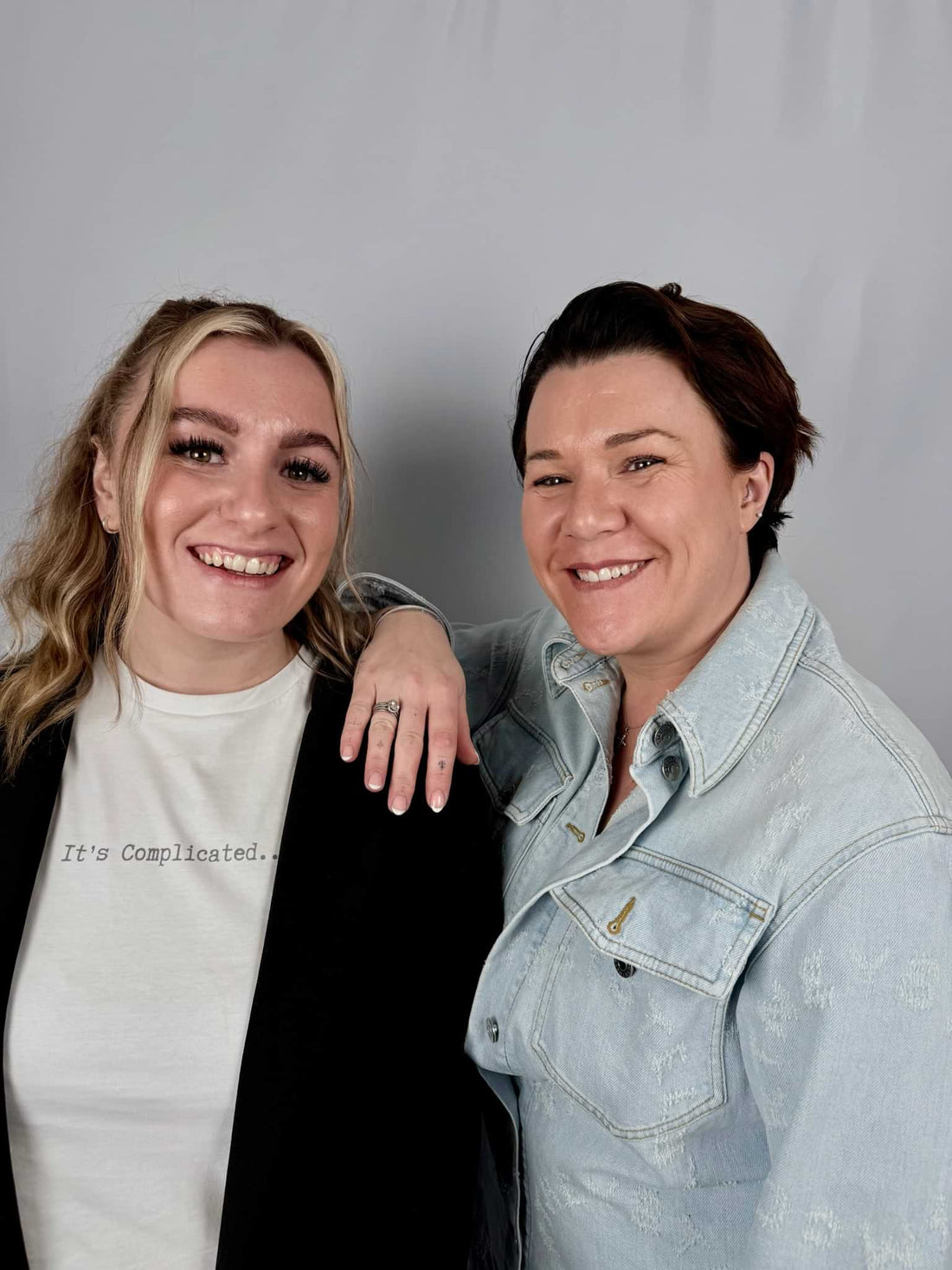 picture of two woman smiling one with black cardigan and one with denim shirt