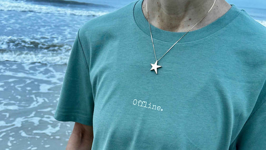 woman wearing a green offline t-shirt by the sea