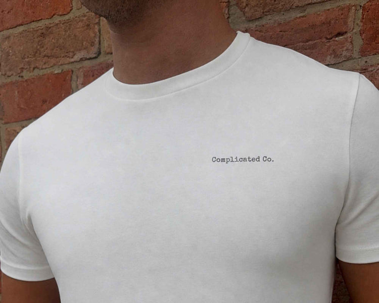 man wearing a white top that says complicated co