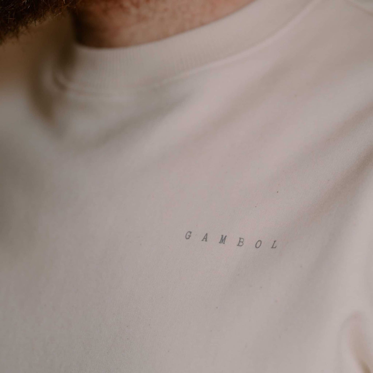 Close-up of a white shirt with 'GAMBOL' printed on it.