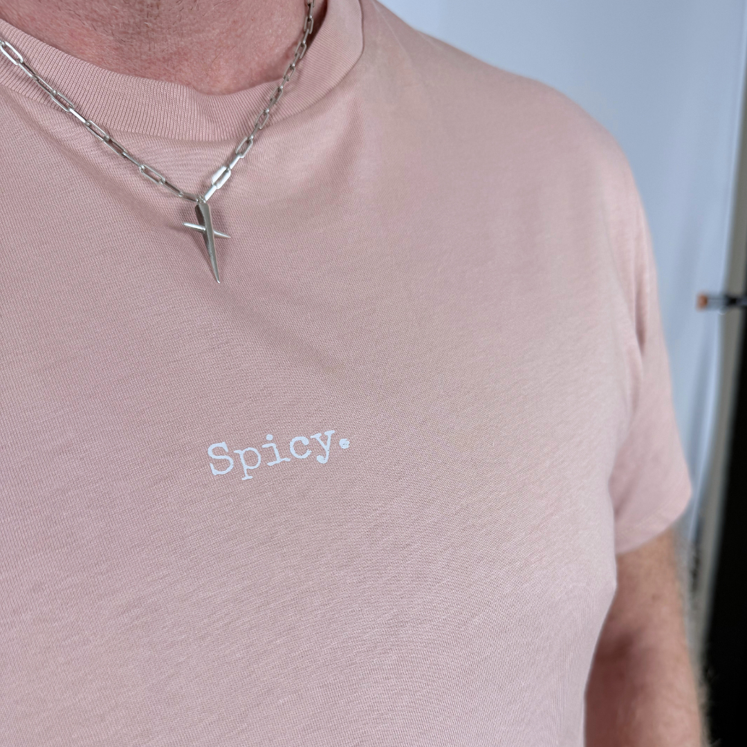 Person wearing a pink shirt with 'Spicy.' text and a necklace.