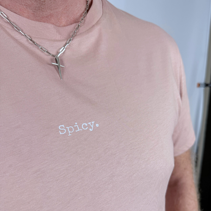 Person wearing a pink shirt with 'Spicy.' text and a necklace.