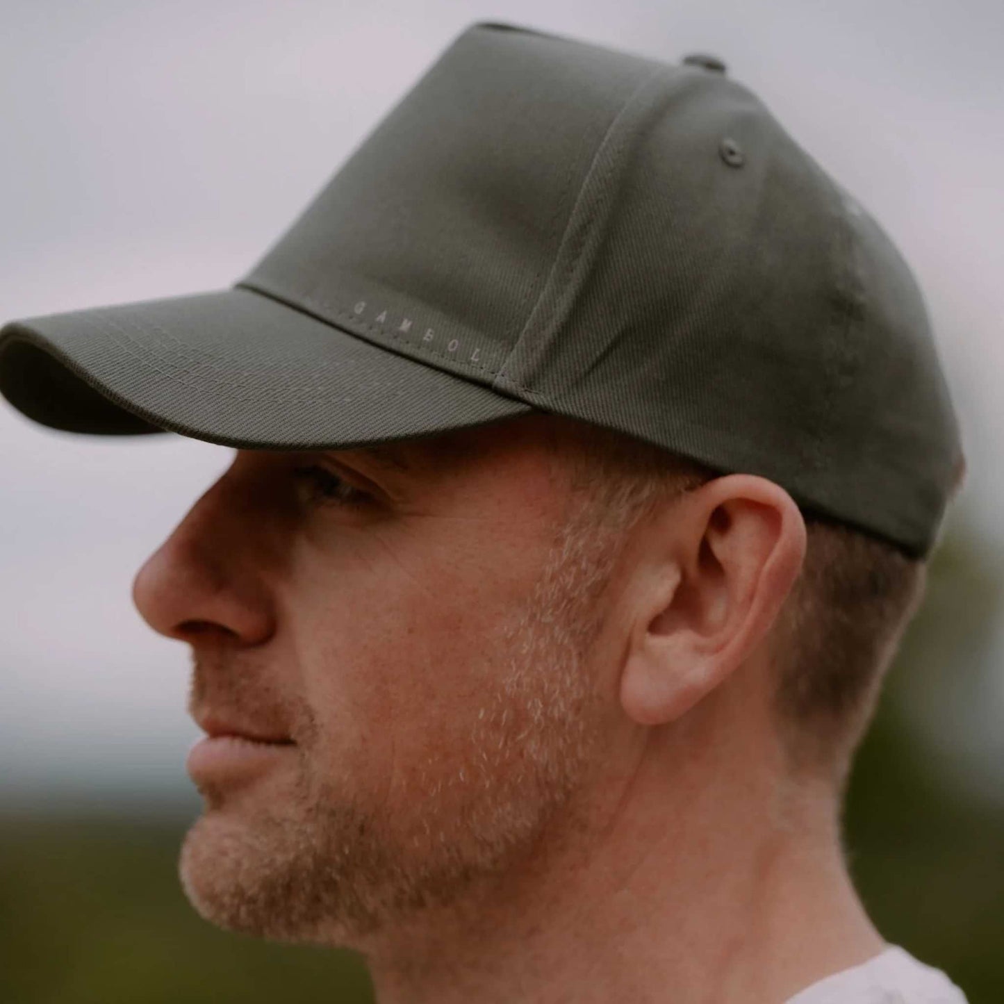 Man wearing a green cap with a blurred background