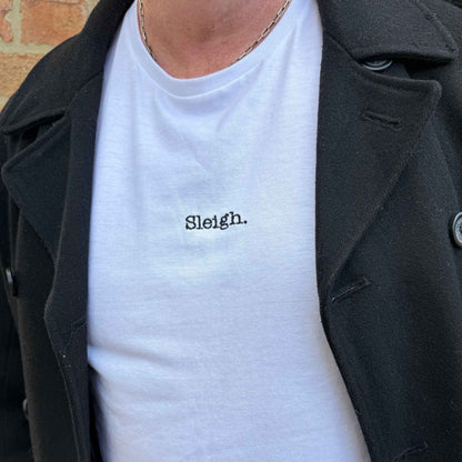 A man in a black coat wearing a white sleigh t-shirt