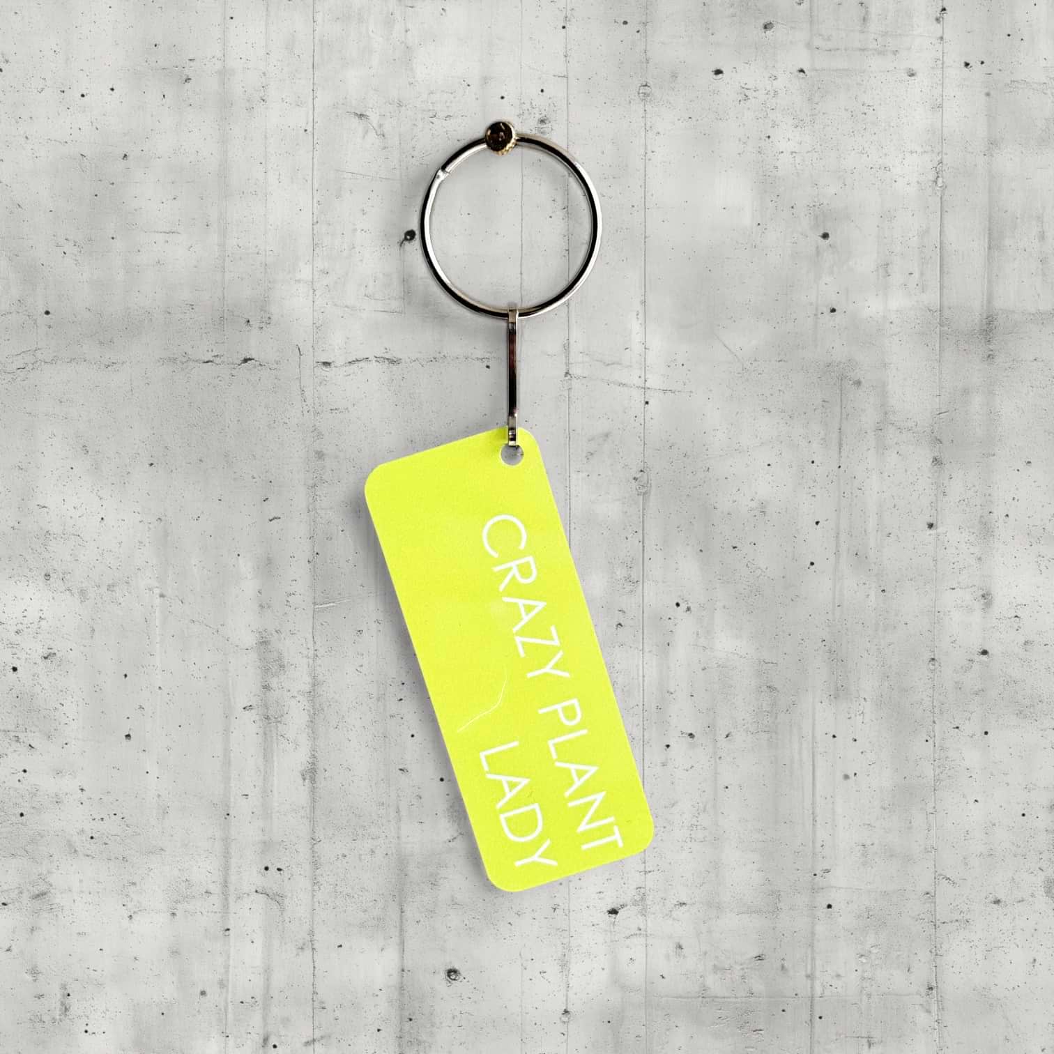 Keychain with 'Crazy Plant Lady' tag on a concrete surface