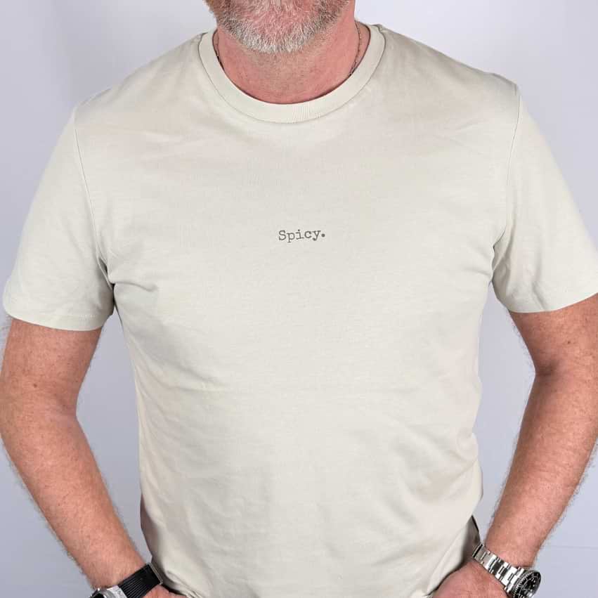 Man wearing a beige t-shirt with 'Spicy' text on a plain background