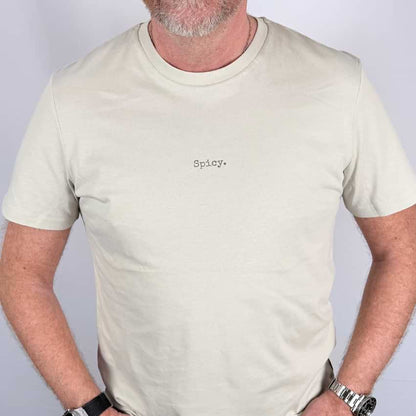 Man wearing a beige t-shirt with 'Spicy' text on a plain background