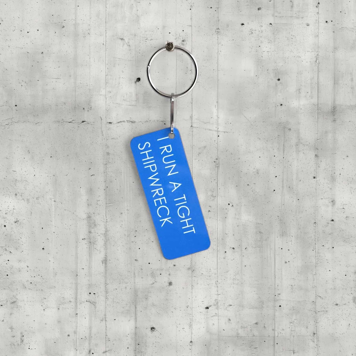 Blue keychain with text on a concrete surface