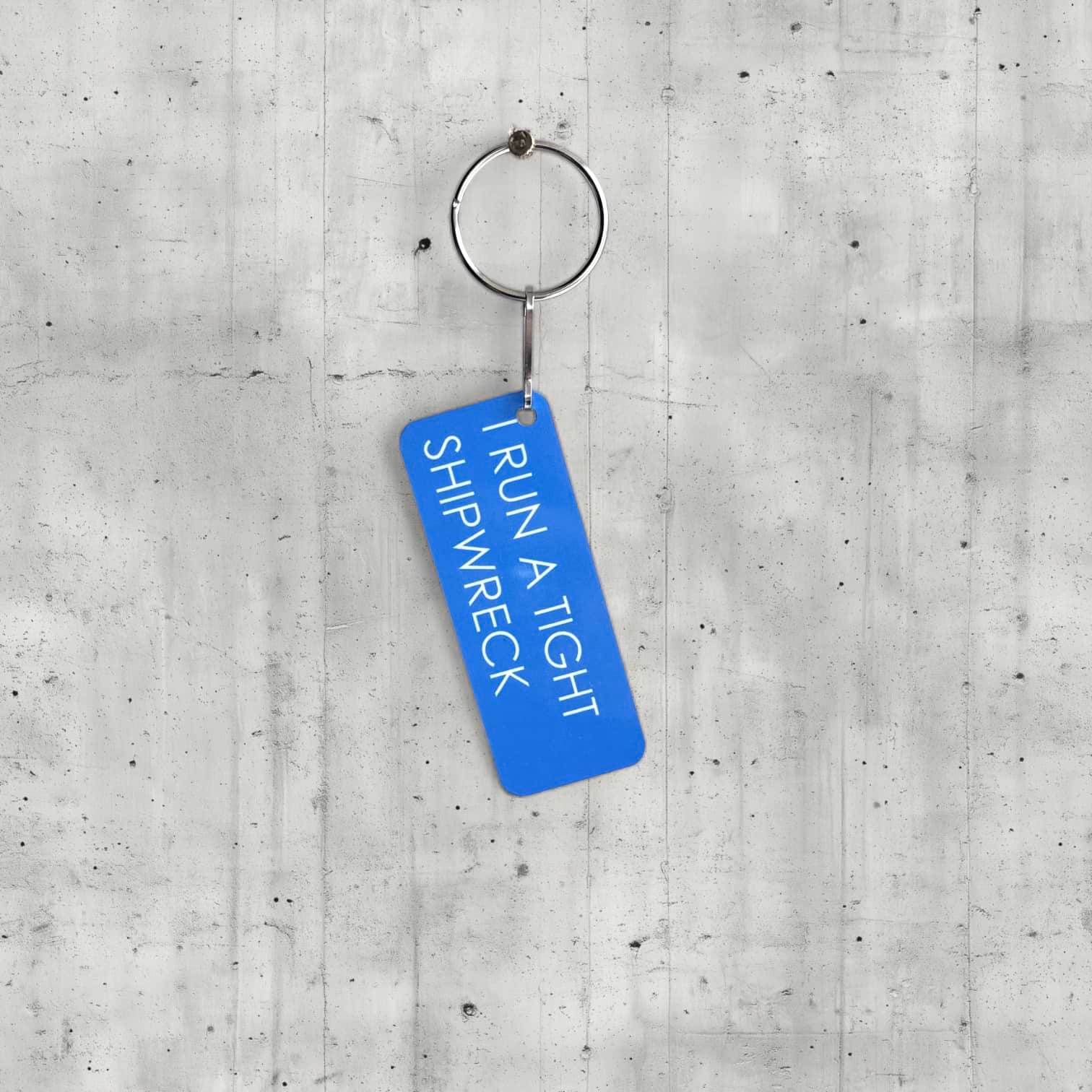 Blue keychain with text on a concrete surface
