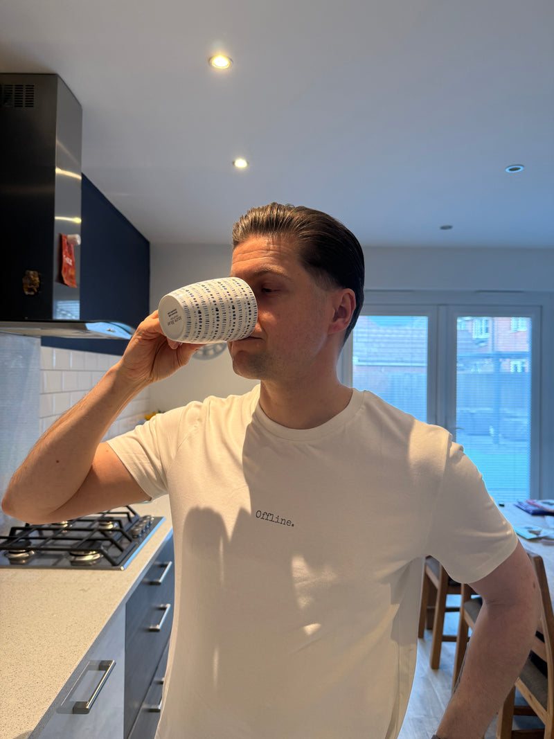 Person drinking from a coffee cup in a kitchen