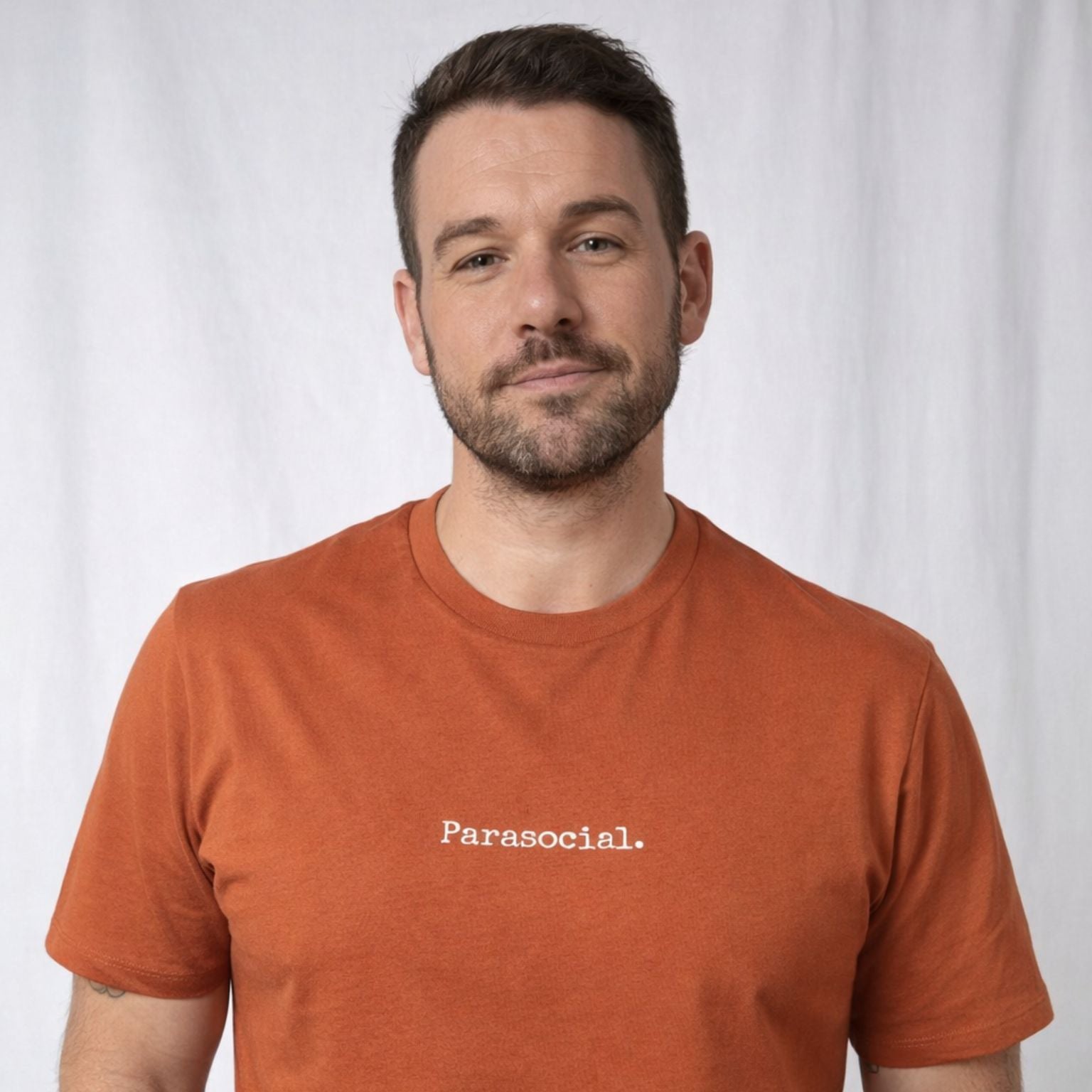 Man wearing a brown t-shirt with 'Parasocial' text on a white background