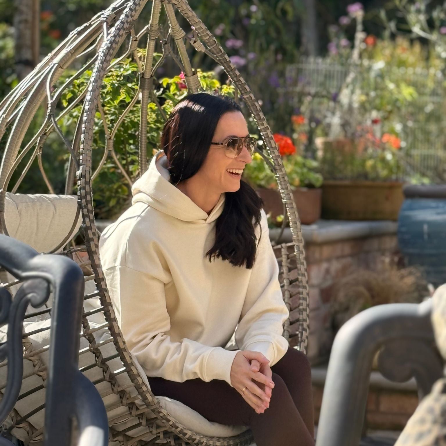 Woman sitting on a decorative chair in a garden setting