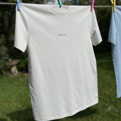 White t-shirt with 'Offline' text hanging on a clothesline outdoors.