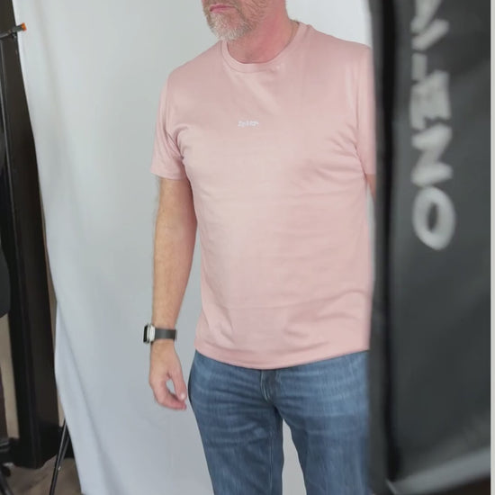 Behind the scenes of a photoshoot short video with a man in a pink t-shirt that says spicy