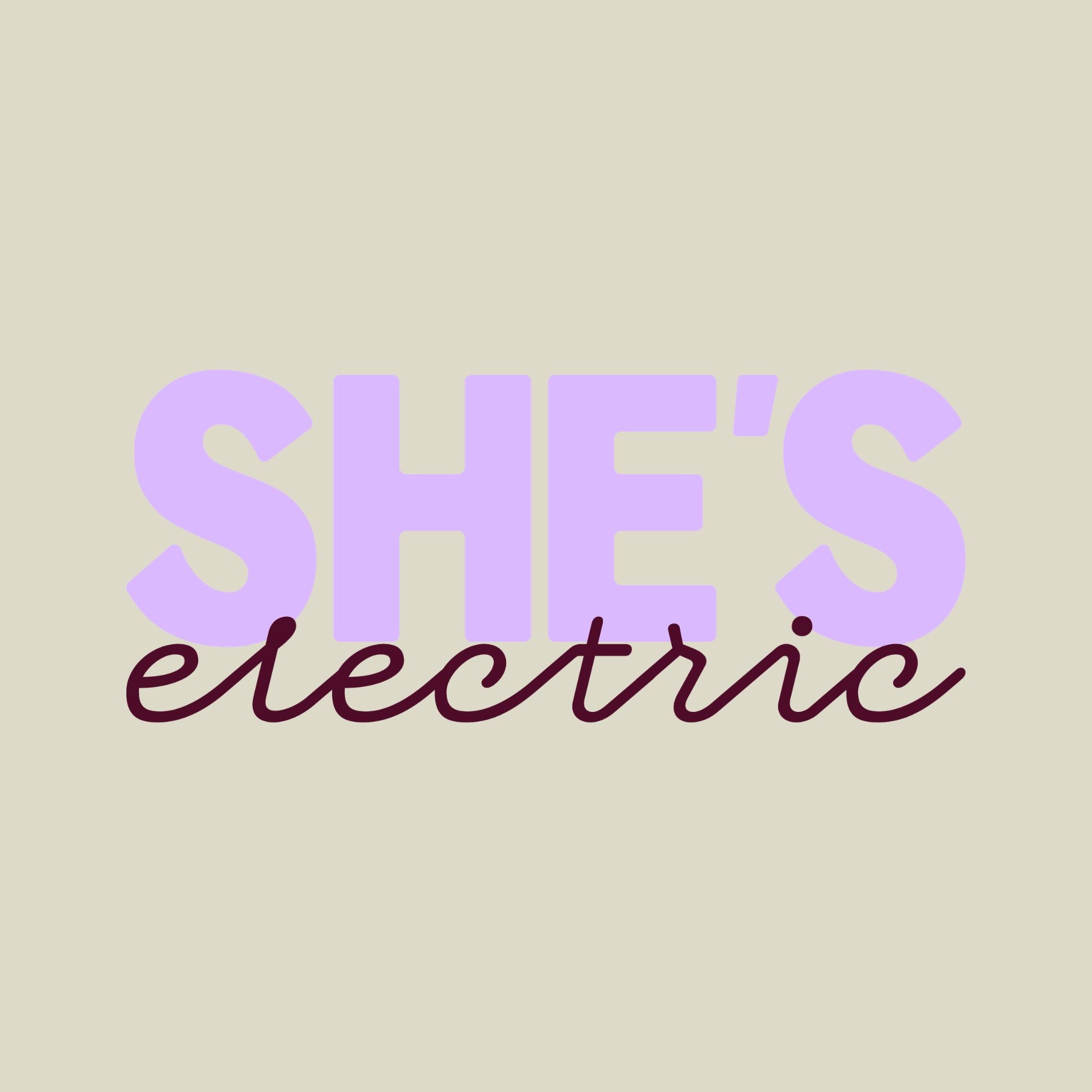 Text 'SHE'S electric' in purple and red on a beige background
